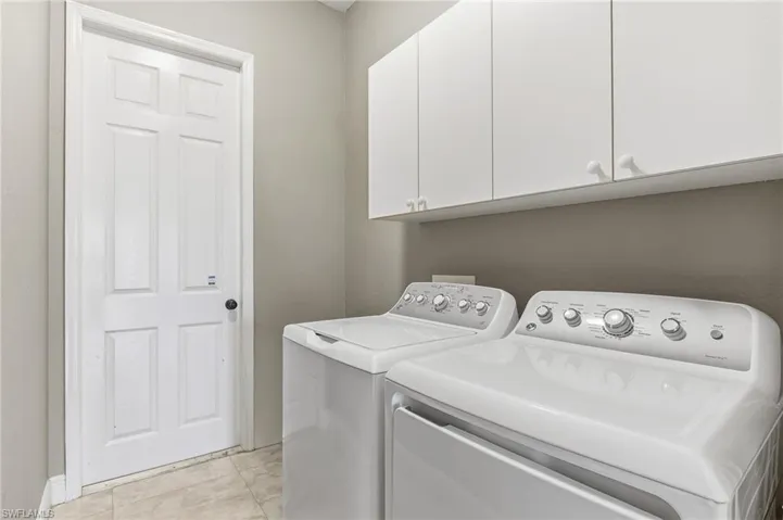 Washroom featuring washing machine and clothes dryer and cabinet space
