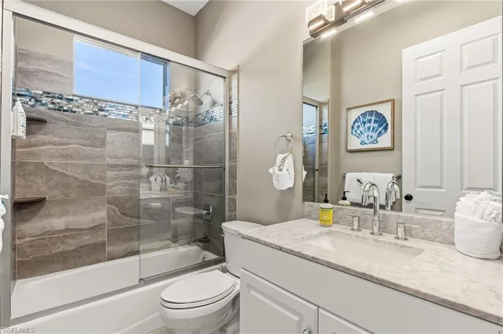 Bathroom featuring vanity and enclosed tub / shower combo