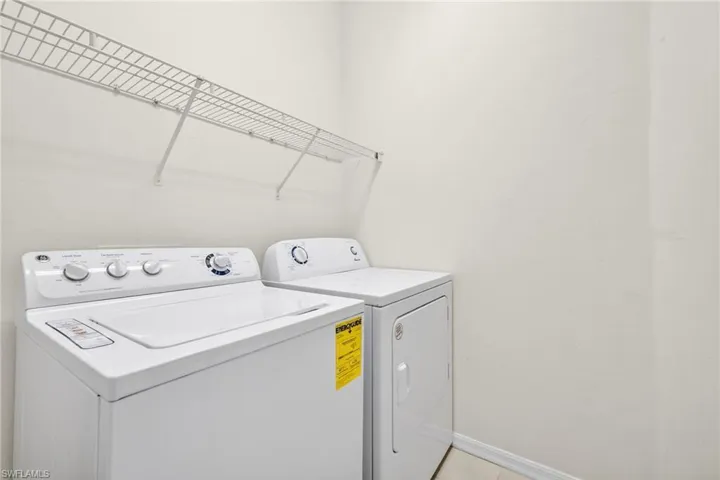 Laundry area with washer and clothes dryer and baseboards