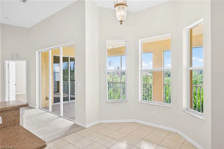 Doorway featuring a chandelier, tile patterned floors, and carpet