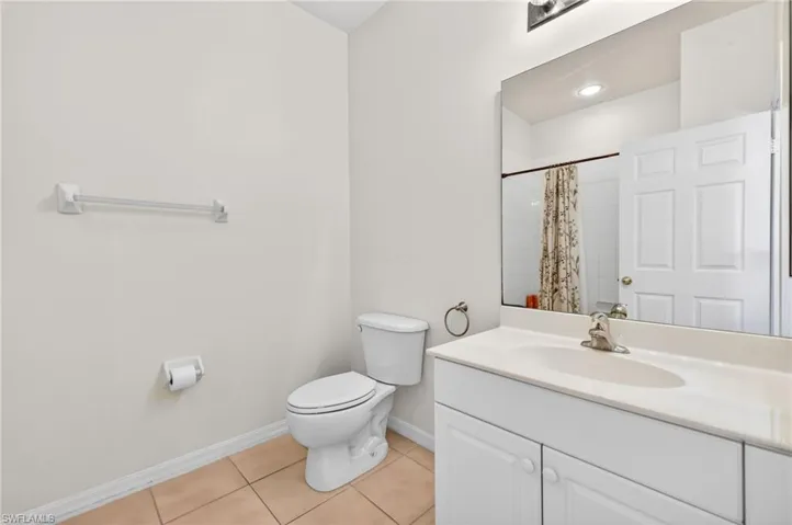 Bathroom featuring vanity, a shower with curtain, and light tile patterned flooring