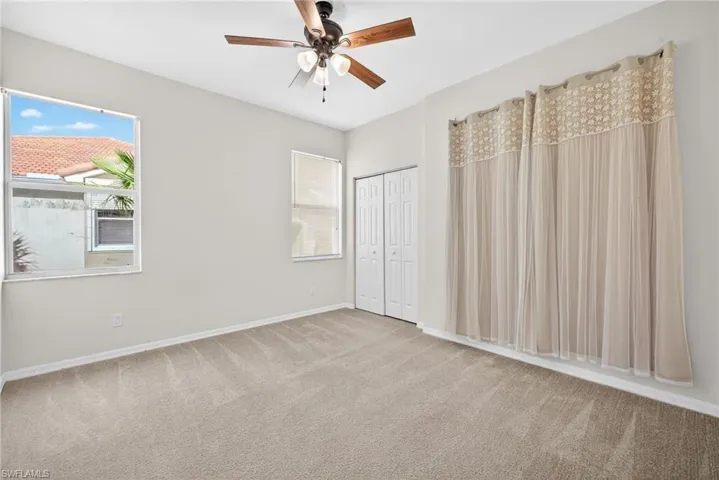 Unfurnished bedroom with carpet, ceiling fan, and a closet