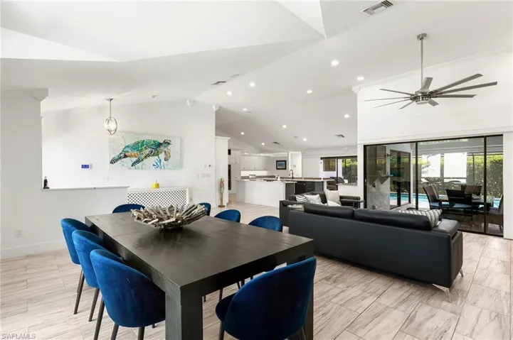 Tiled dining space featuring ceiling fan and high vaulted ceiling