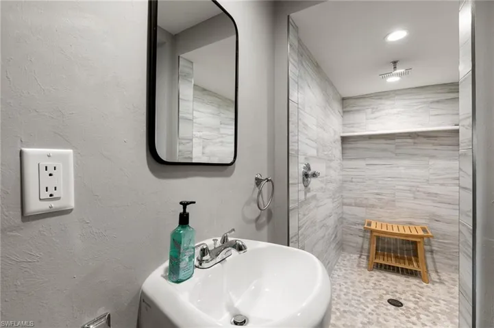 Bathroom featuring sink and a tile shower