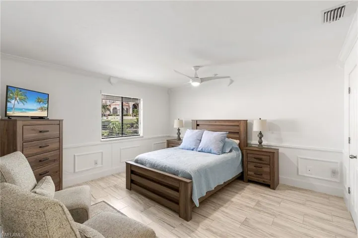 Bedroom with ceiling fan and ornamental molding
