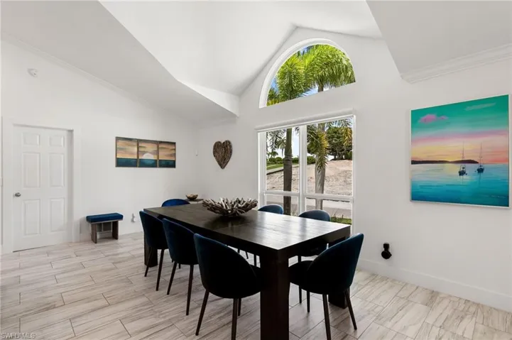 Dining room featuring plenty of natural light, lofted ceiling, ornamental molding, and light tile patterned floors