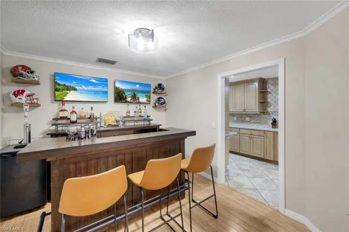 Dedicated entertainment space featuring a built-in bar with a wooden base and a dark countertop