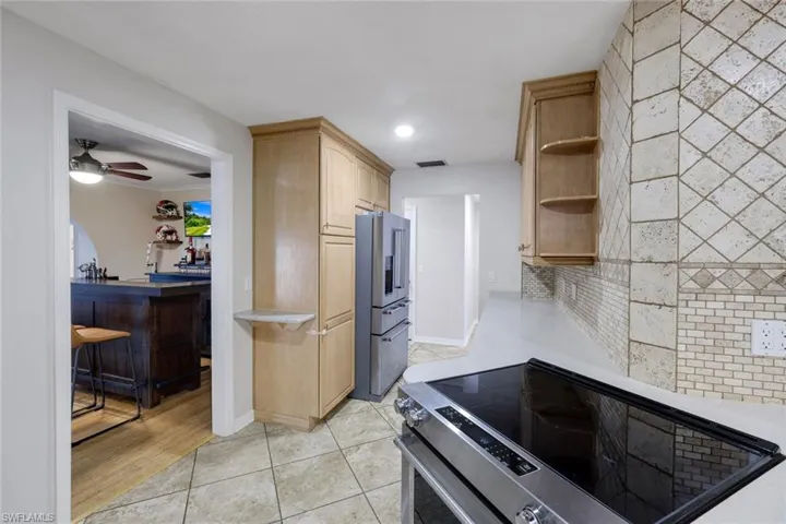 Kitchen featuring a stainless steel electric range, light countertops, and a decorative tile backsplash
