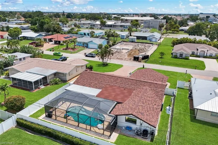 Residential property featuring a screened-in pool, manicured lawn, and privacy fencing