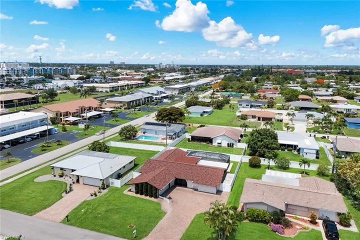 Aerial perspective of a residential neighborhood featuring single-story homes with shingle and flat roofs