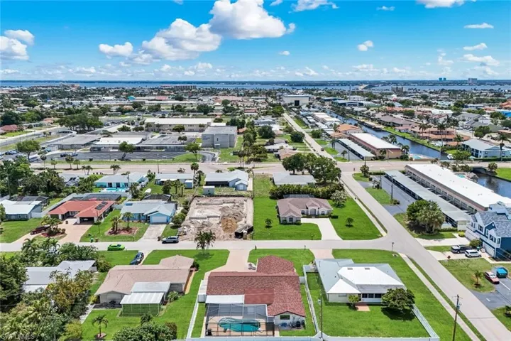 Aerial perspective showcasing a residential community with waterways and distant coastal elements