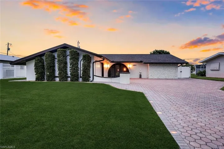Modern ranch-style residence featuring a white stucco exterior and dark trim