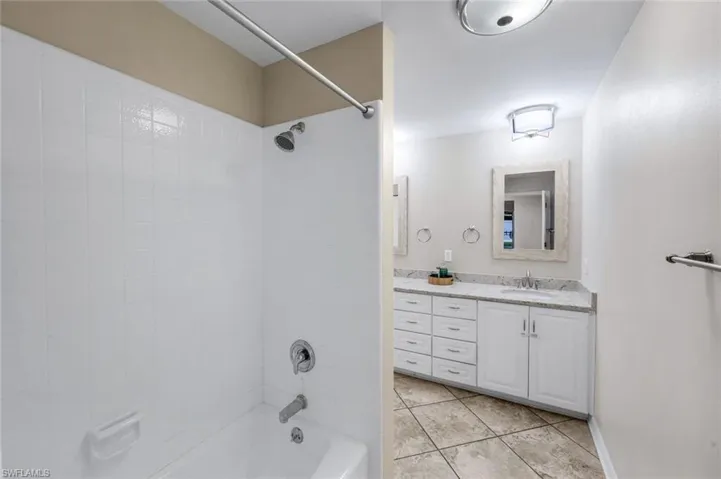 Bathtub and shower combination with white tile surround