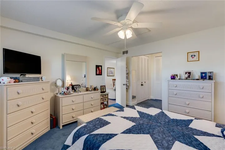 Primary bedroom featuring a ceiling fan and a custom closet