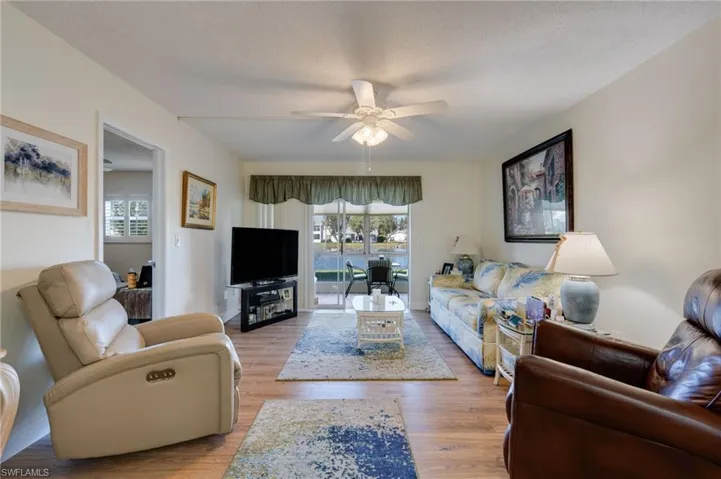 Living room with lots ofnatural light, wood look finished floorsand two leather chairs