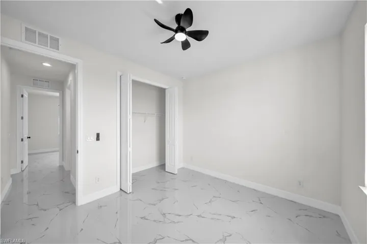 Unfurnished bedroom with baseboards, marble finish floor, and visible vents