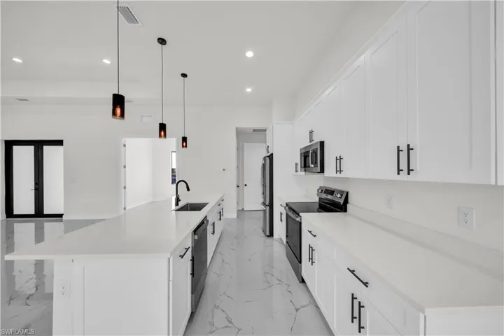 Kitchen with marble finish floor, a sink, stainless steel appliances, and recessed lighting