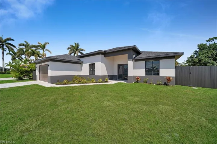 Prairie-style house with a front lawn, stucco siding, a garage, and concrete driveway