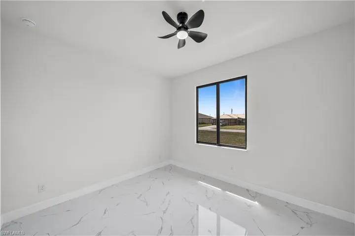 Unfurnished room with baseboards, marble finish floor, and a ceiling fan