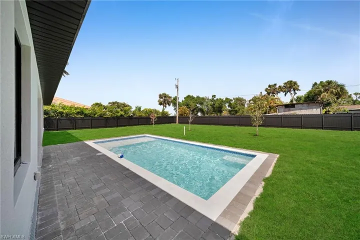 View of swimming pool with a fenced backyard, a patio, and a yard
