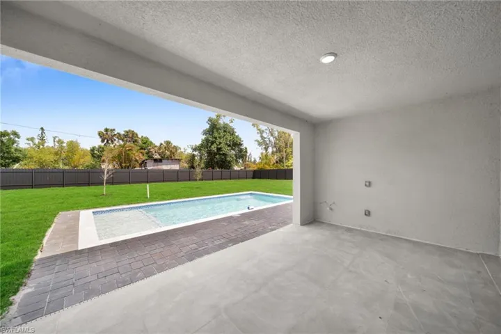 View of swimming pool featuring a fenced backyard, a fenced in pool, a lawn, and a patio area