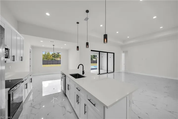 Kitchen featuring open floor plan, recessed lighting, a sink, and stainless steel appliances
