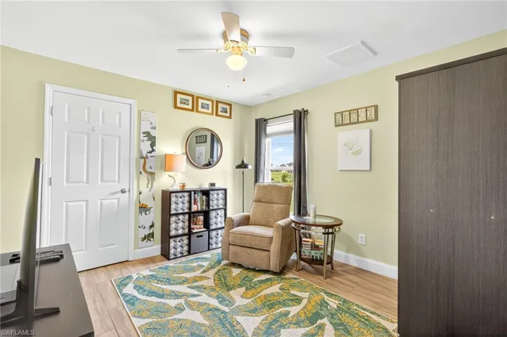 Living area with ceiling fan and light wood finished floors