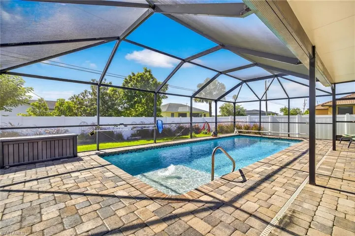 View of pool featuring a fenced backyard, a patio area, and glass enclosure