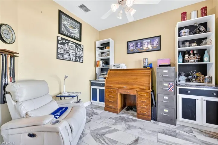 Office with a ceiling fan and marble finish flooring