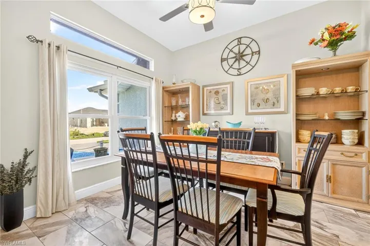Dining area featuring light marble finish flooring, ceiling fan, and healthy amount of natural light