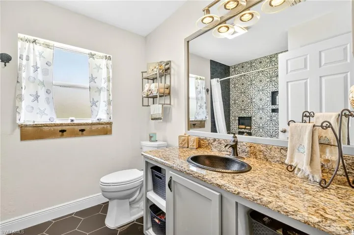 Bathroom with vanity, tile patterned floors, and a shower with shower curtain