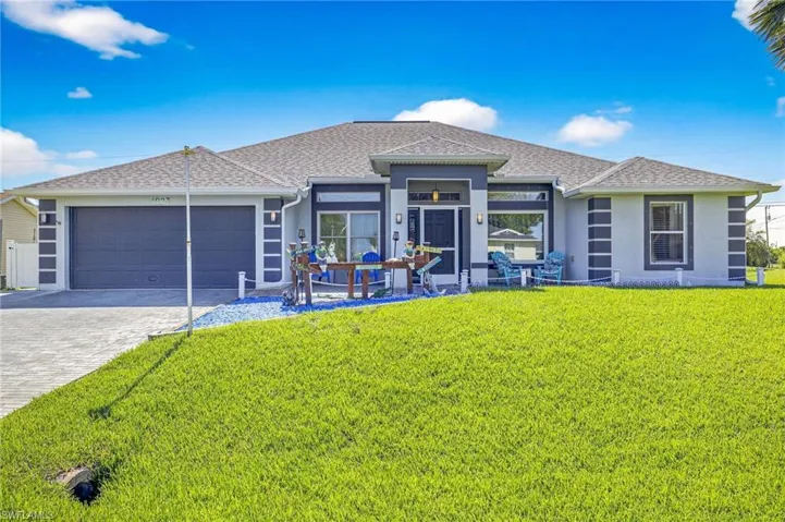 Single story home featuring stucco siding, a garage, decorative driveway, a front lawn, and a shingled roof