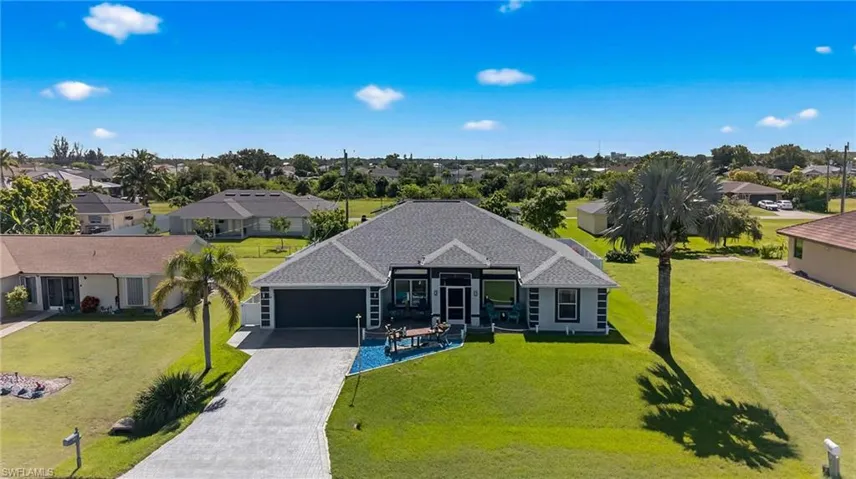 View of front of home featuring decorative driveway, a garage, and a front lawn