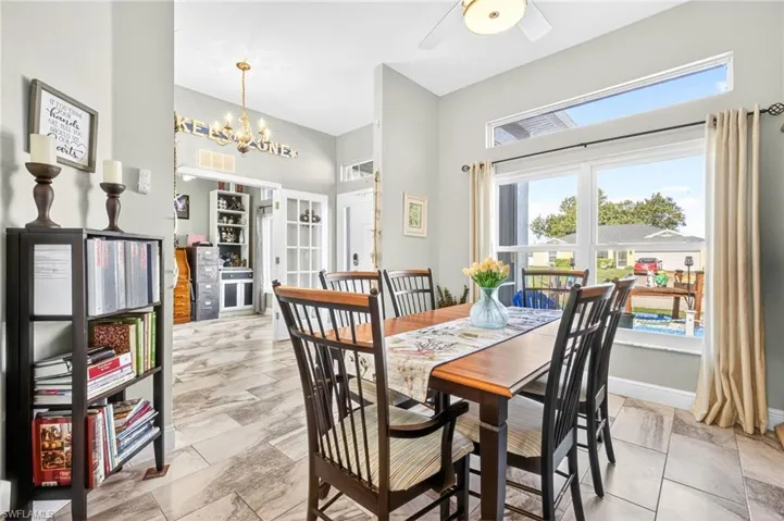 Dining room featuring a chandelier, a high ceiling, and ceiling fan