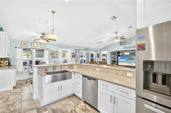 Kitchen featuring ceiling fan, appliances with stainless steel finishes, healthy amount of natural light, and lofted ceiling
