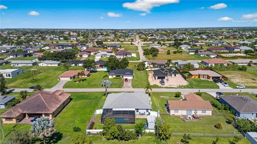 Aerial view of property and surrounding area with nearby suburban area