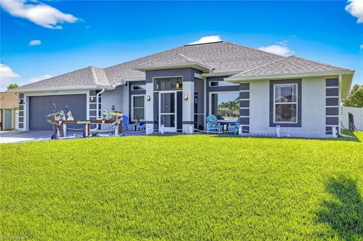 View of front of house with stucco siding, a shingled roof, an attached garage, and a front lawn