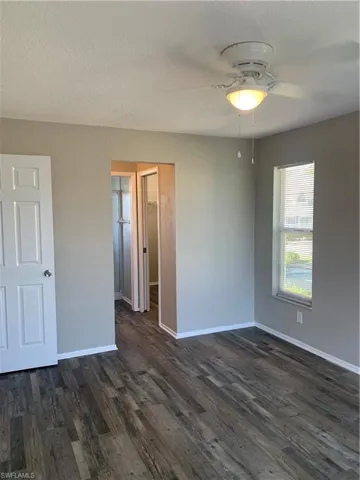 Master bedroom featuring a textured ceiling, dark hardwood / wood-style floors, and ceiling fan