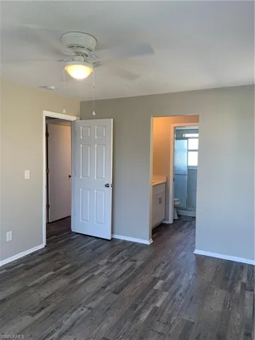 Master bedroom featuring ceiling fan and dark wood-type flooring