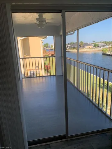 Balcony with a water view and ceiling fan