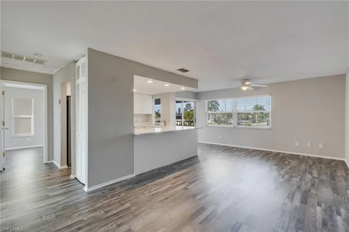 Unfurnished living room with dark wood-style floors, ceiling fan, and recessed lighting