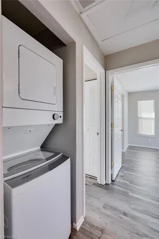 Laundry room featuring stacked washer / drying machine and light wood finished floors