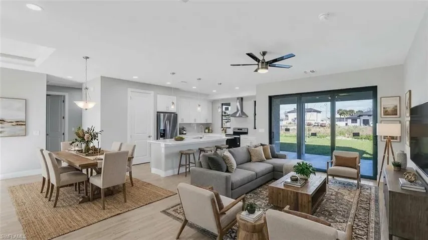 Living room featuring light wood-style flooring, ceiling fan, and recessed lighting