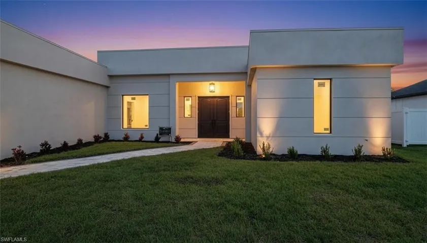 View of front of home featuring a yard and stucco siding