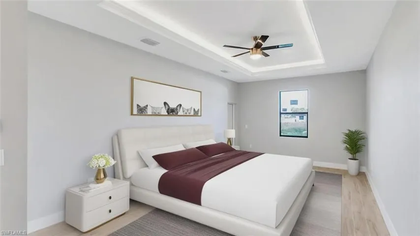 Bedroom featuring light wood-style flooring, a raised ceiling, and a ceiling fan