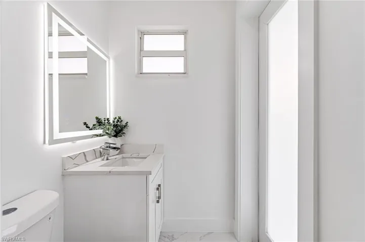 Bathroom featuring vanity, tile patterned flooring, and toilet