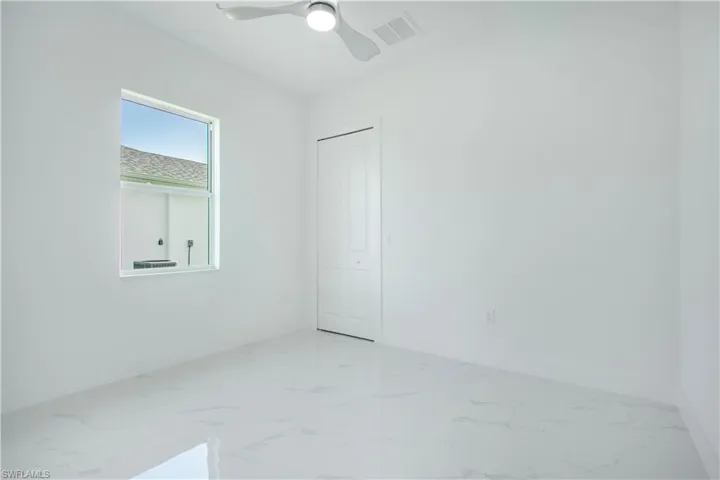 Empty room featuring tile patterned floors and ceiling fan