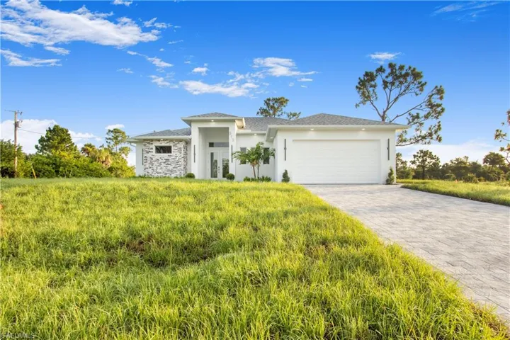 View of front of home with a front lawn and a garage