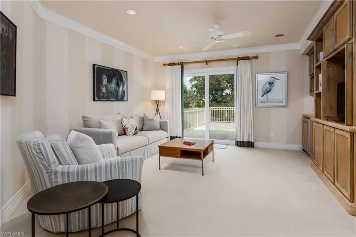 Living room with ornamental molding, ceiling fan, light colored carpet, and recessed lighting