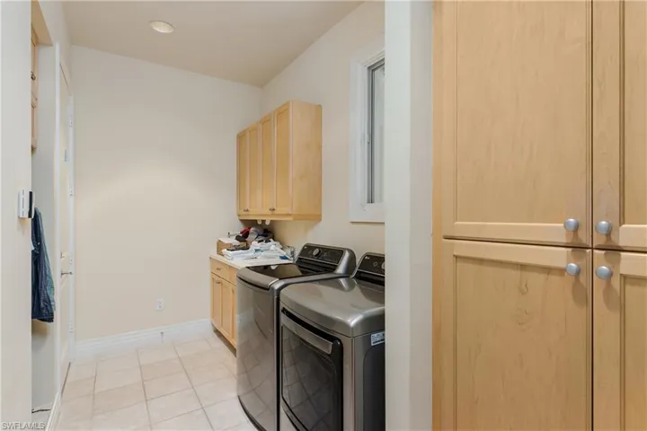 Laundry room featuring cabinet space, washer and clothes dryer, light tile patterned flooring, and recessed lighting